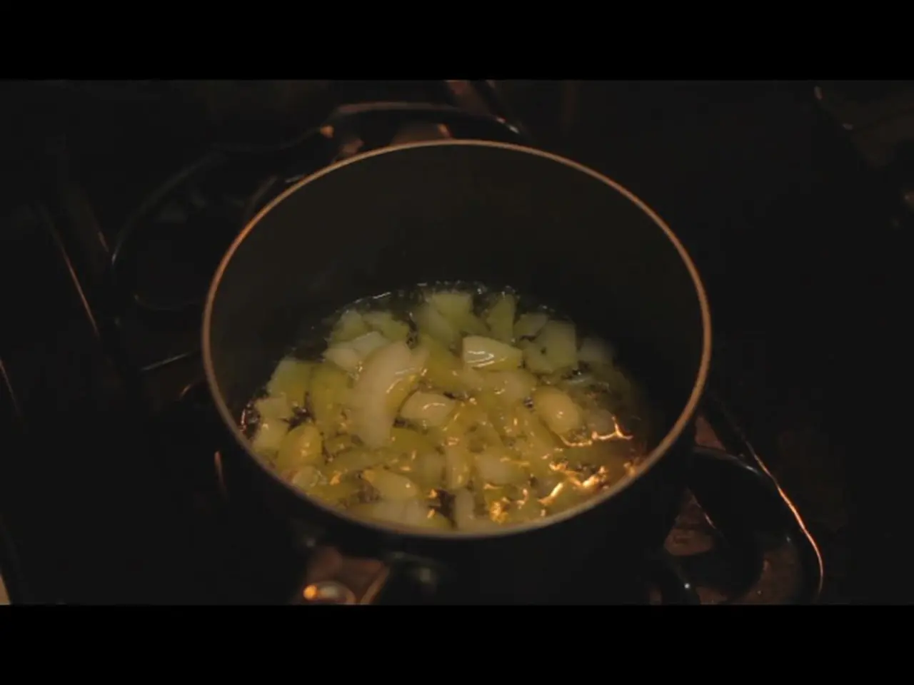 There is a stove and some item is being cooked in a vessel on the stove.