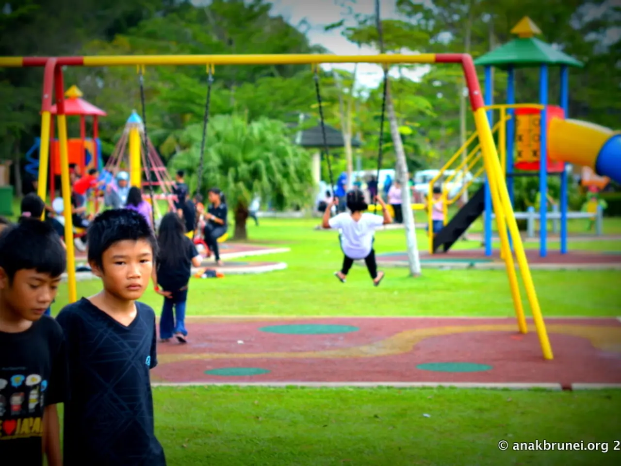 In this image we can see children in the park that includes some playing equipments and trees.