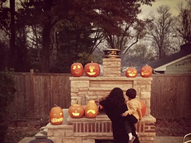 In this image, we can see a person carrying a kid on the path. Behind them, there are carving...