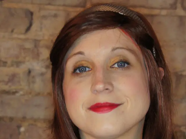 In this image, we can see a lady wearing a hair band and in the background, there is a wall. At the...