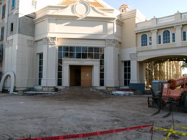 Building with glass windows. Here we can see a vehicle and tree.